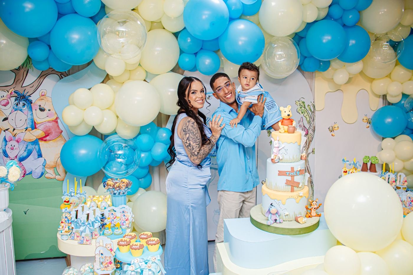 Família com o aniversariante ao lado do bolo