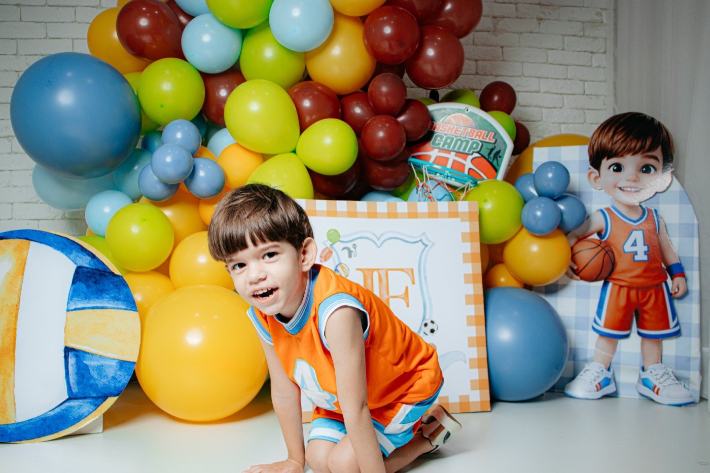 Menino brincando entre balões coloridos