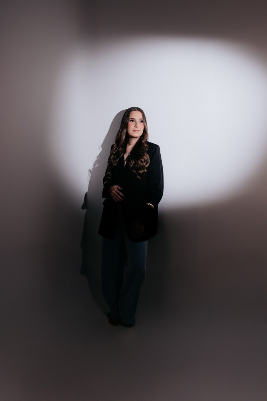 Retrato feminino com blazer preto sob foco de luz