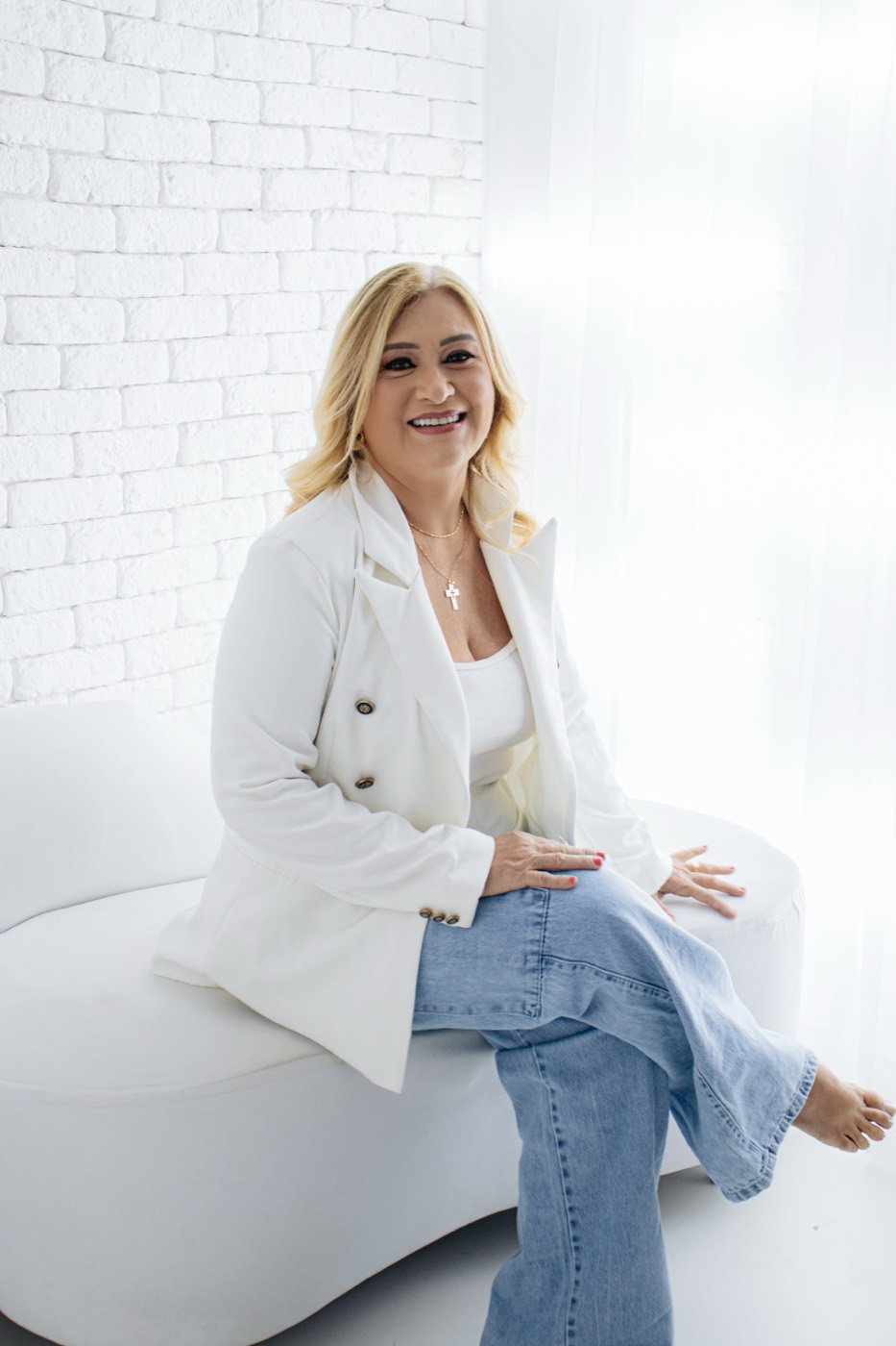 Retrato feminino de blazer branco no sofá