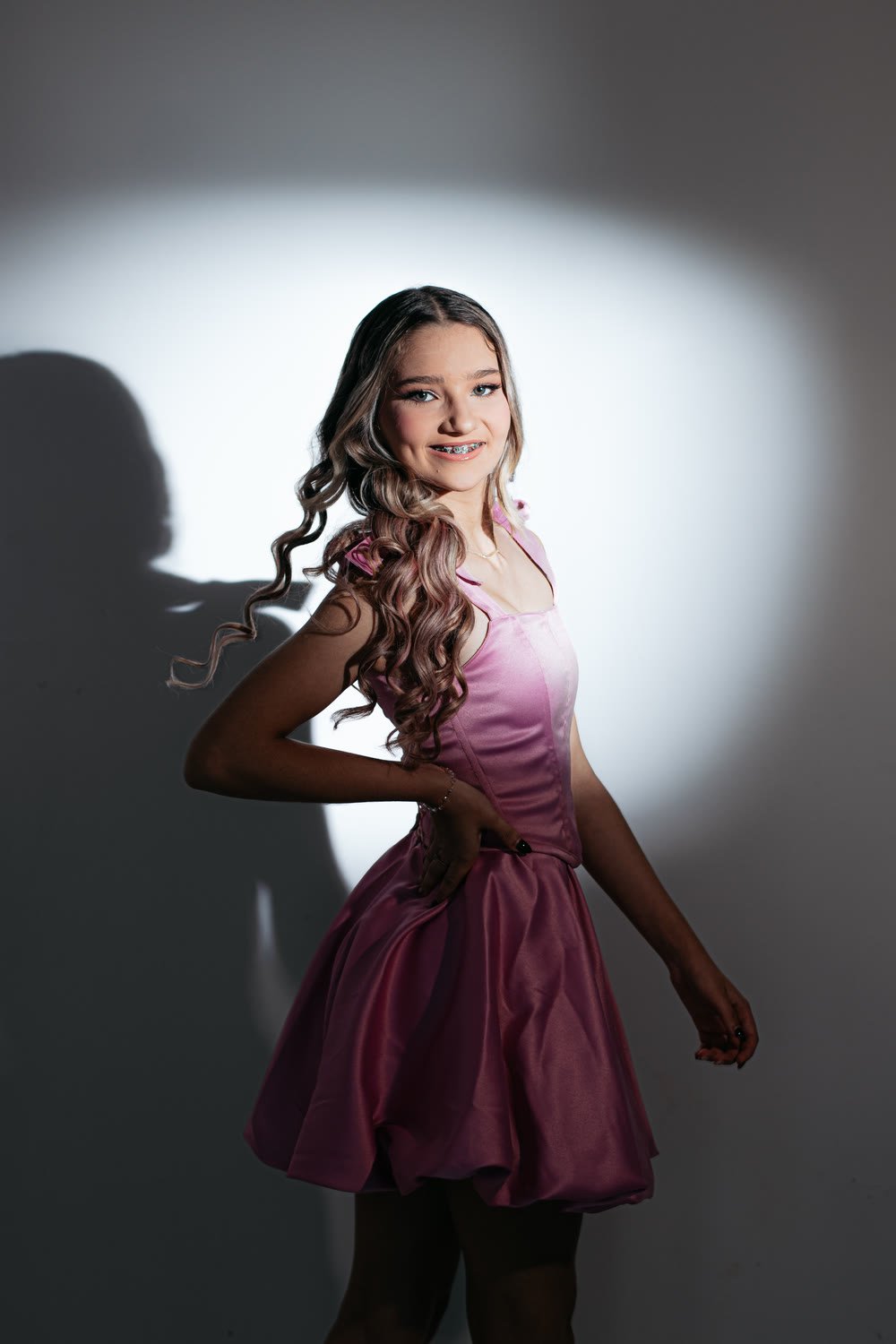 Retrato de vestido rosa sob foco de luz