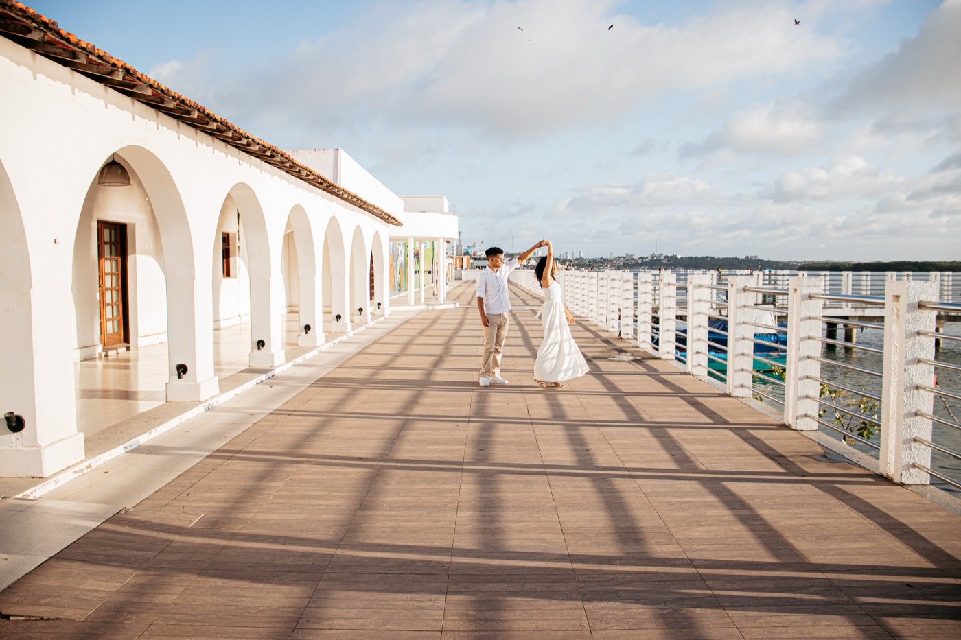 Casal caminhando entre arcos ao fim da tarde